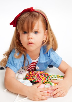 Greedy girl with pile of sweets